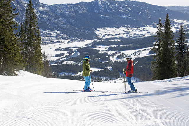 Skidkare p manchestersn i solen med Hemsedal i bakgrund